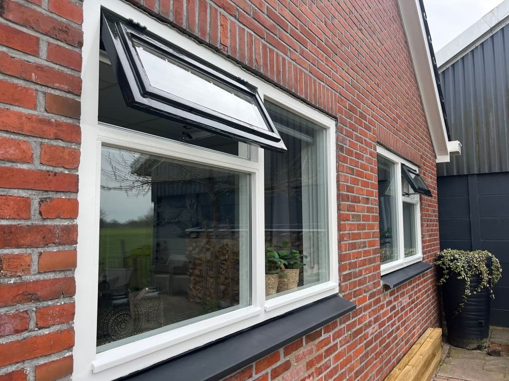 Buitenschilderwerk: strak geverfde kozijnen tegen rode baksteen — N. Boersma Schilderwerken, Drachten